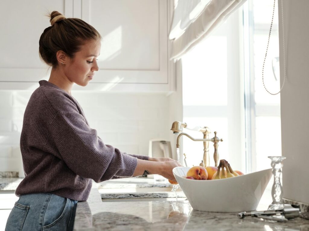 Rinsing fruits under faucet – clean prep areas require backflow-free systems.