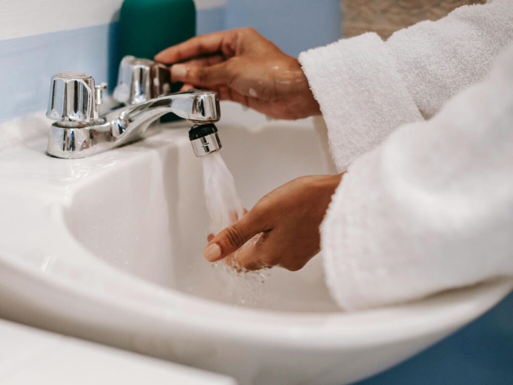 Turning on faucet – everyday action requiring safe, controlled and clean water flow.