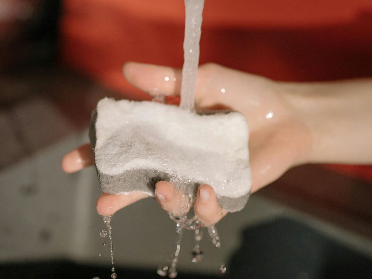 Washing dishes with scrubber – clean water necessary for healthy meals.