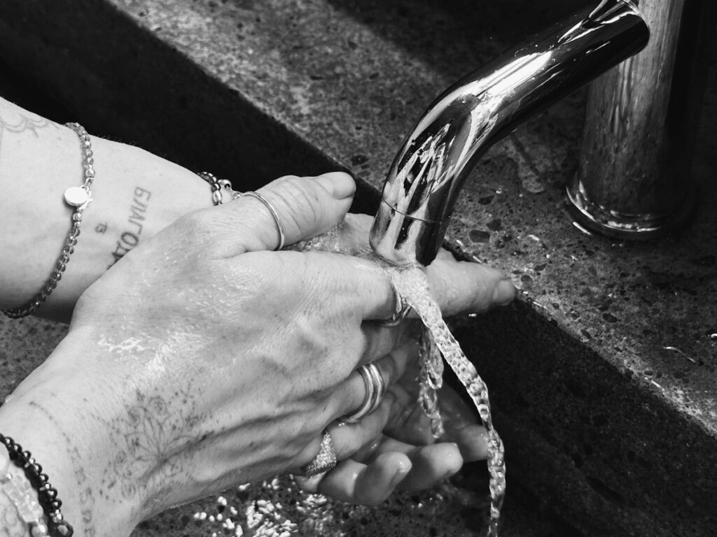 Rinsing hands at rustic sink – even older systems need backflow protection.