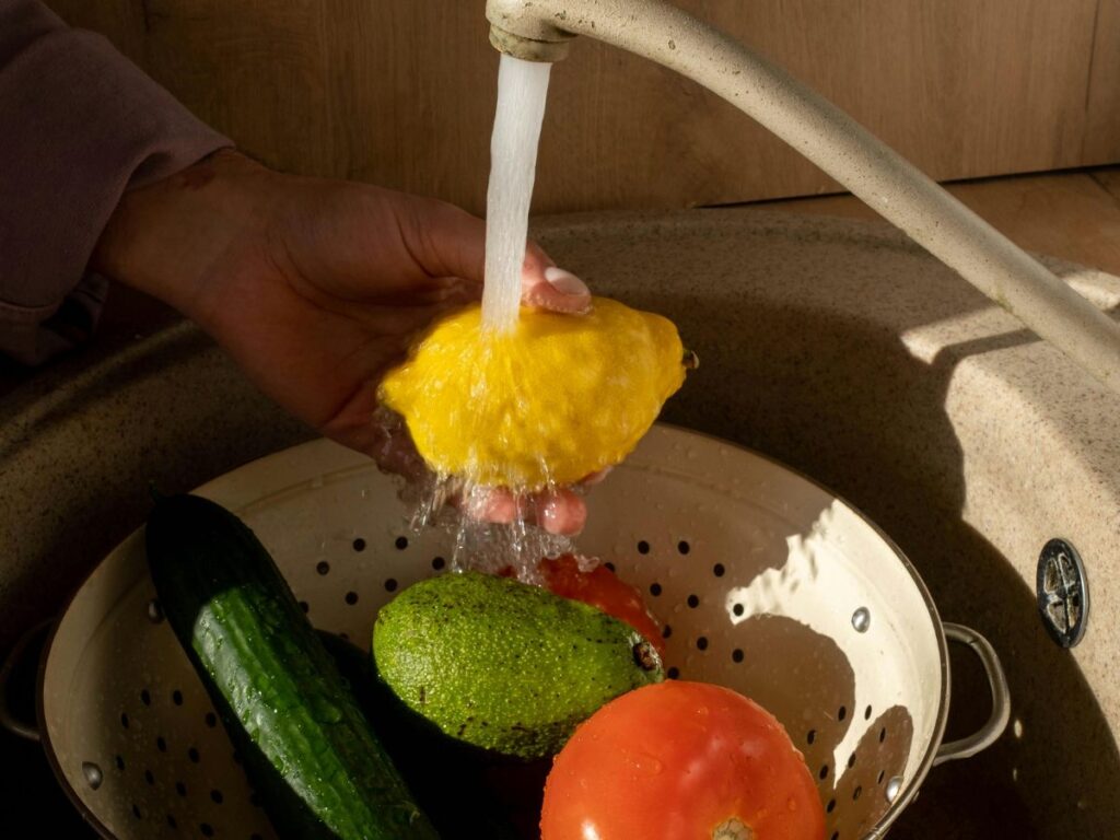 Washing vegetables with scrubber – clean water necessary for healthy meals.