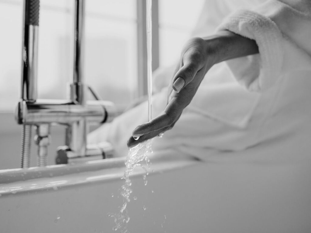 Hand under bathroom faucet – shows accessibility of clean water.