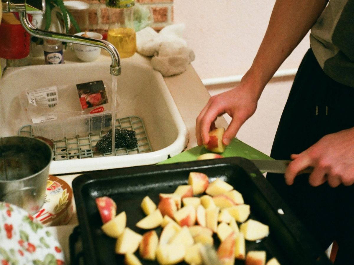 Rinsing apples in a kitchen sink – highlighting importance of uncontaminated water for food prep.
