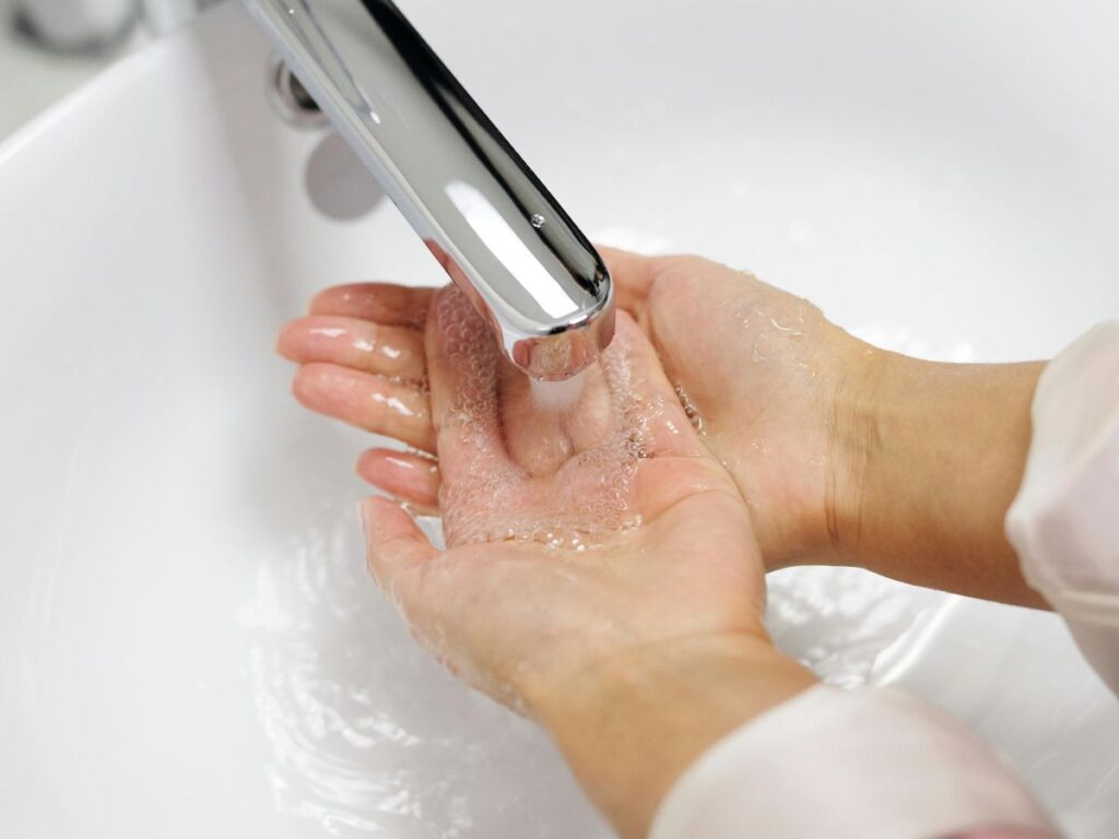 Woman drinking from cupped hands – trust in water purity.
