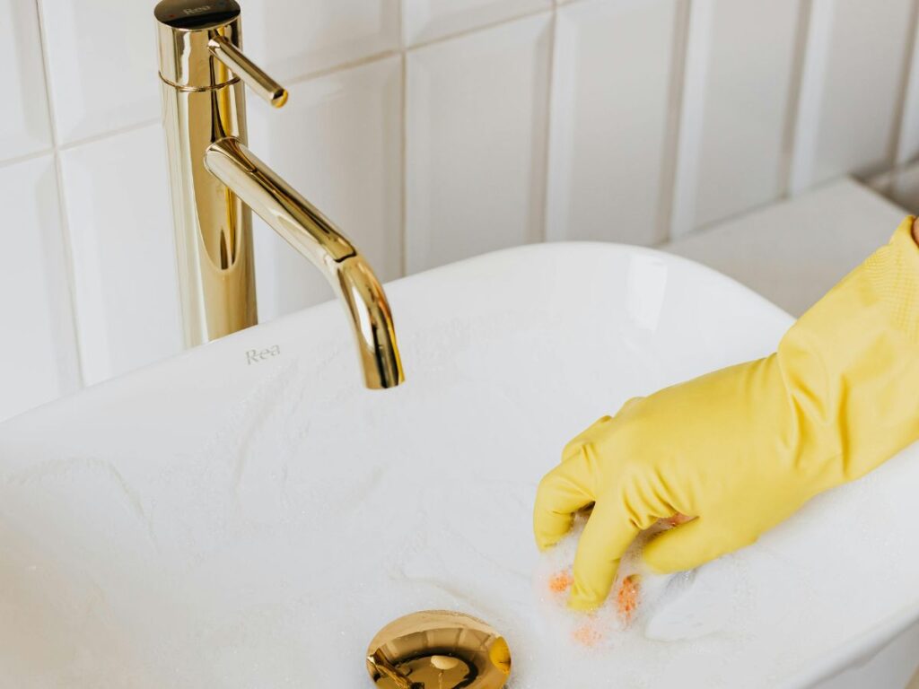 Cleaning glass dish with gloves – kitchen safety with clean water.