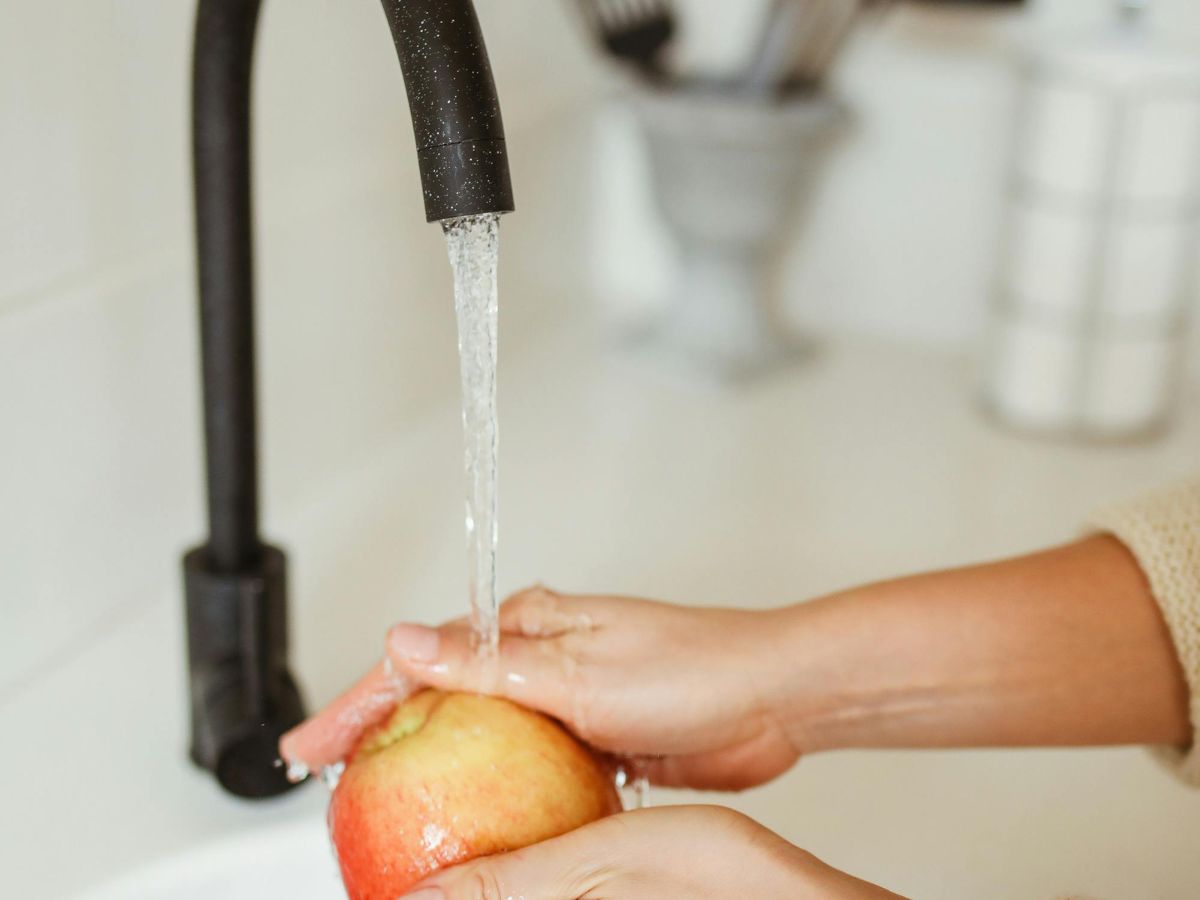 Apple being rinsed – prevents consumption of contaminated water.