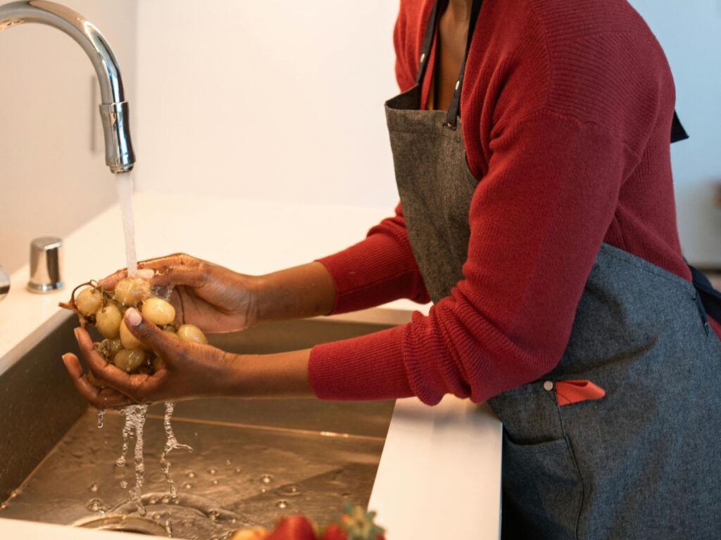Washing produce under running water – risk-free water for healthy living.