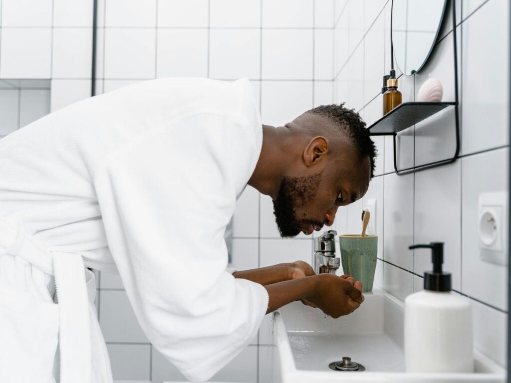 Man washing face – personal hygiene depends on safe, backflow-free water.
